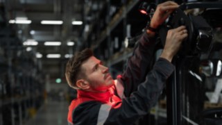 I sistemi di illuminazione e segnalazione di Linde Material Handling consentono una movimentazione sicura e precisa. Tecnico dell'assistenza Linde durante l'installazione di una soluzione di illuminazione