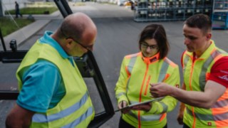 Tre persone con gilet ad alta visibilità mentre parlano: consulenza sulla sicurezza in loco presso la sede del cliente. Tre persone con gilet ad alta visibilità mentre parlano: consulenza sulla sicurezza in loco presso la sede del cliente.