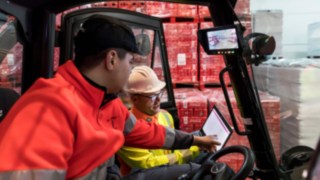 Un esperto di sicurezza di Linde MH mostra a un conducente di carrelli elevatori i dati su un tablet. Un esperto di sicurezza di Linde MH mostra a un conducente di carrelli elevatori i dati su un tablet.