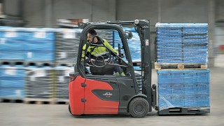 Un collaboratore di DB Schenker che fa marcia indietro su un carrello elevatore elettrico Linde E16 Un collaboratore di DB Schenker che fa marcia indietro su un carrello elevatore elettrico Linde E16