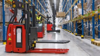 I carrelli elevatori automatizzati e a comando manuale di Linde MH si muovono all'interno di un magazzino.