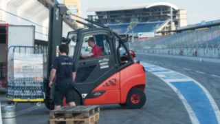 I carrelli elevatori a noleggio di Linde trasportano casse d’acqua per il montaggio dell’evento Formula Student sul circuito dell’Hockenheimring I carrelli elevatori a noleggio di Linde durante le operazioni di montaggio sul circuito dell’Hockenheimring