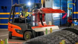 Un dipendente di Michelin Tyre PLC afferra una pila di pneumatici con una pinza per pneumatici sul Linde E20.