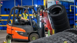 Un dipendente della Michelin Tyre PLC afferra una pila di pneumatici con una pinza montata sul carrello elevatore.