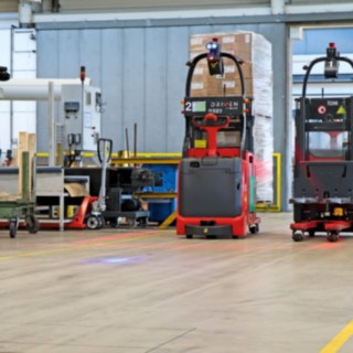 Due stoccatori automatici L-MATIC trasportano le merci tra la linea di imballaggio e il magazzino a flusso continuo.