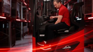 Vista laterale di un operatore mentre lavora con il carrello retrattile ergonomico Linde Material Handling Ri16.