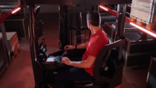 Un operatore è seduto nella cabina ergonomica del carrello retrattile Linde Material Handling Ri16.