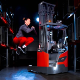Un atleta salta in alto accanto al carrello retrattile Linde Material Handling Ri16.