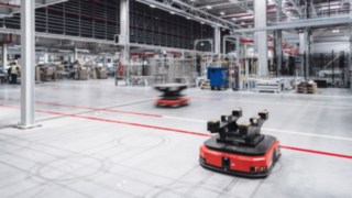 I robot di trasporto autonomi in un moderno capannone logistico sono sinonimo di tecnologia all'avanguardia, soluzioni di automazione intelligenti e cultura aziendale innovativa presso KION.