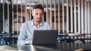 Il project manager gestisce con attenzione i progetti sul suo laptop in un ambiente internazionale presso Linde. 