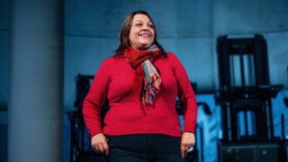 Una collaboratrice del reparto vendite posa con sicurezza davanti a una serie di moderni carrelli industriali Linde, simboleggiando la vicinanza al cliente, l'entusiasmo per le soluzioni innovative e l'impatto globale di un lavoro di vendita di successo. 