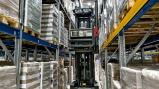 Il Very Narrow Aisle Truck automatizzato Linde K-MATIC percorre la corsia di una scaffalatura.